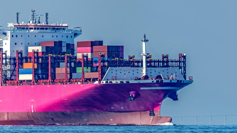 A Pink Container Ship is Sailing on the Sea