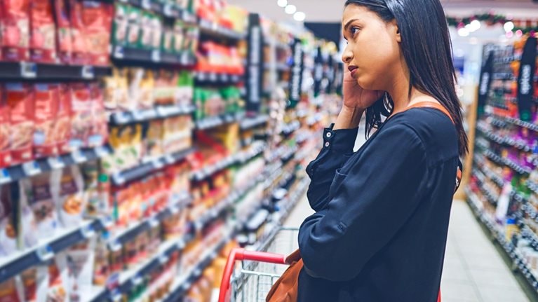 Shot of a concerned young woman shopping in a grocery store