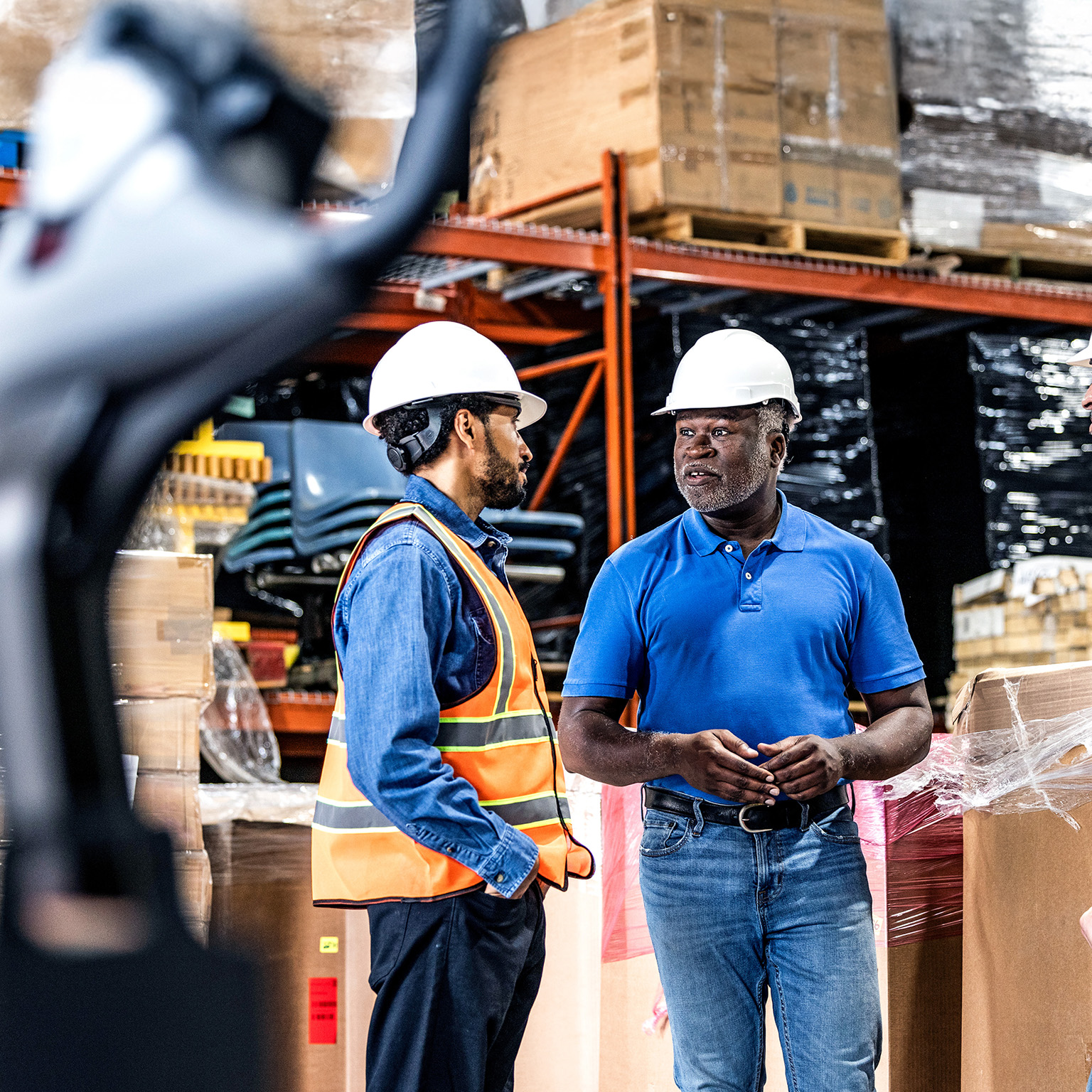 Warehouse supervisor speaking with a group of employees