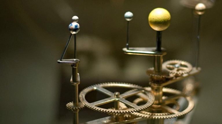 A mechanical device illustrating how the solar system revolves.