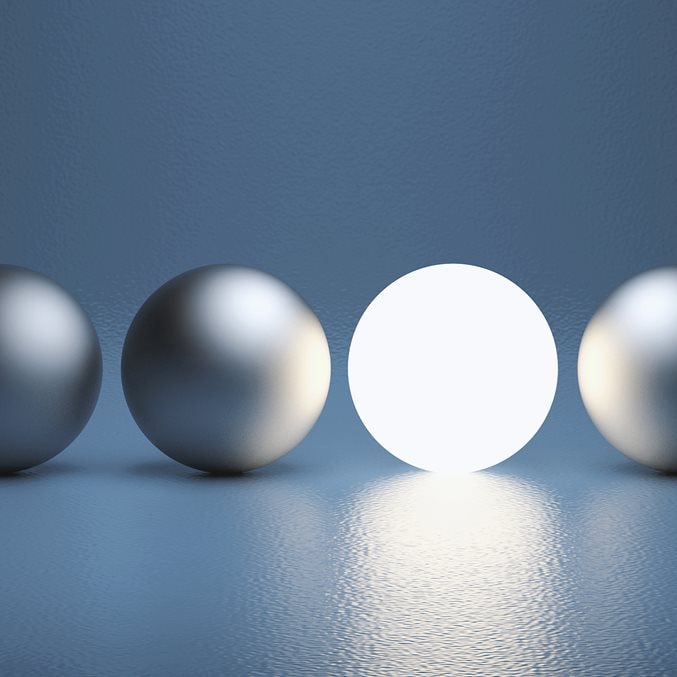 A lit sphere in the midst of three silver spheres.