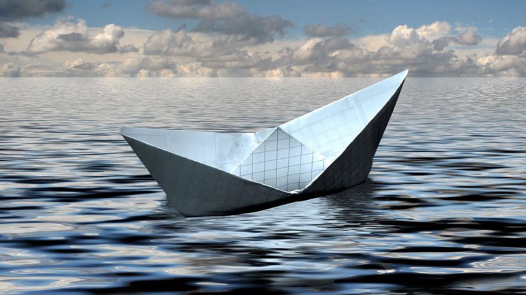 A small boat crafted from graph paper floats gracefully in the ocean, poised for an epic voyage.
