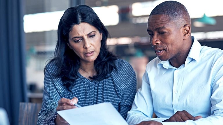 A man and women sit together and review a piece of paper