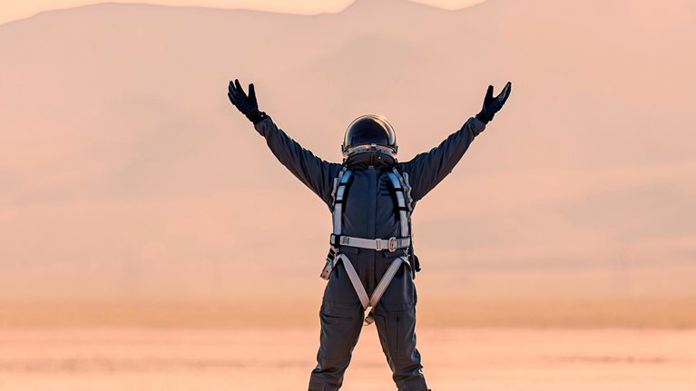 Astronaut raises hands to the sky