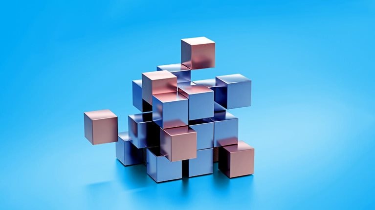 Metal cubes made of silver and gold coming together to form a bigger cube.