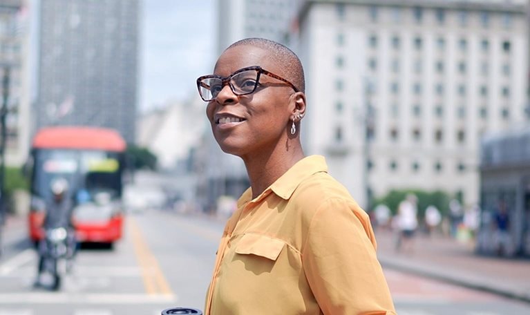 A person crossing the street holding a coffee cup