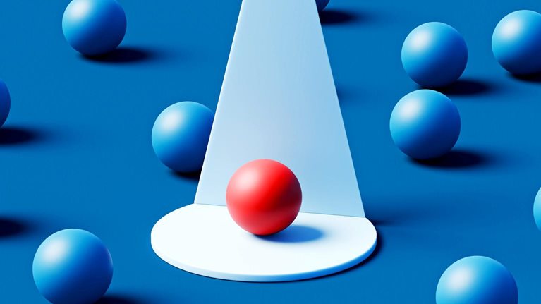 A single red sphere rests on a white circular platform beneath a focused cone of light, standing out vividly among numerous blue spheres scattered across a deep teal background.