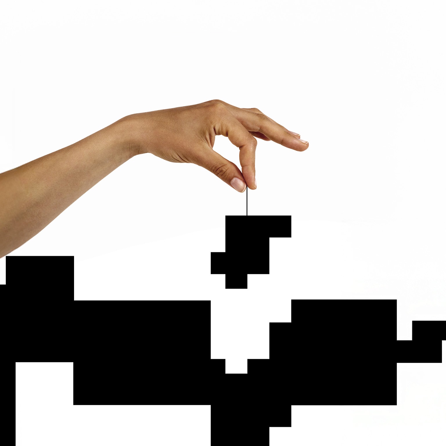 Conceptual image of a hand lowering a puzzle piece into a black and white puzzle.