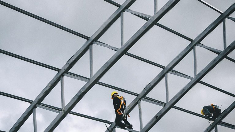 Workers standing on steel scaffolding