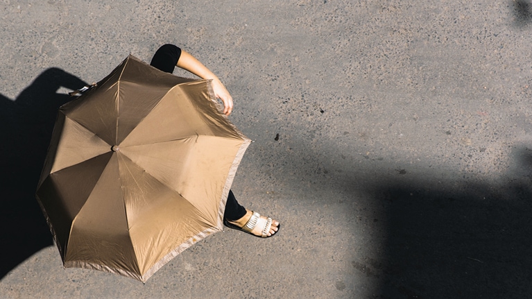 Woman using umbrella as shade from the sun