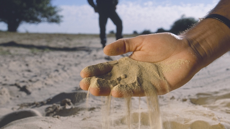 Sand falling from an outstreched  hand