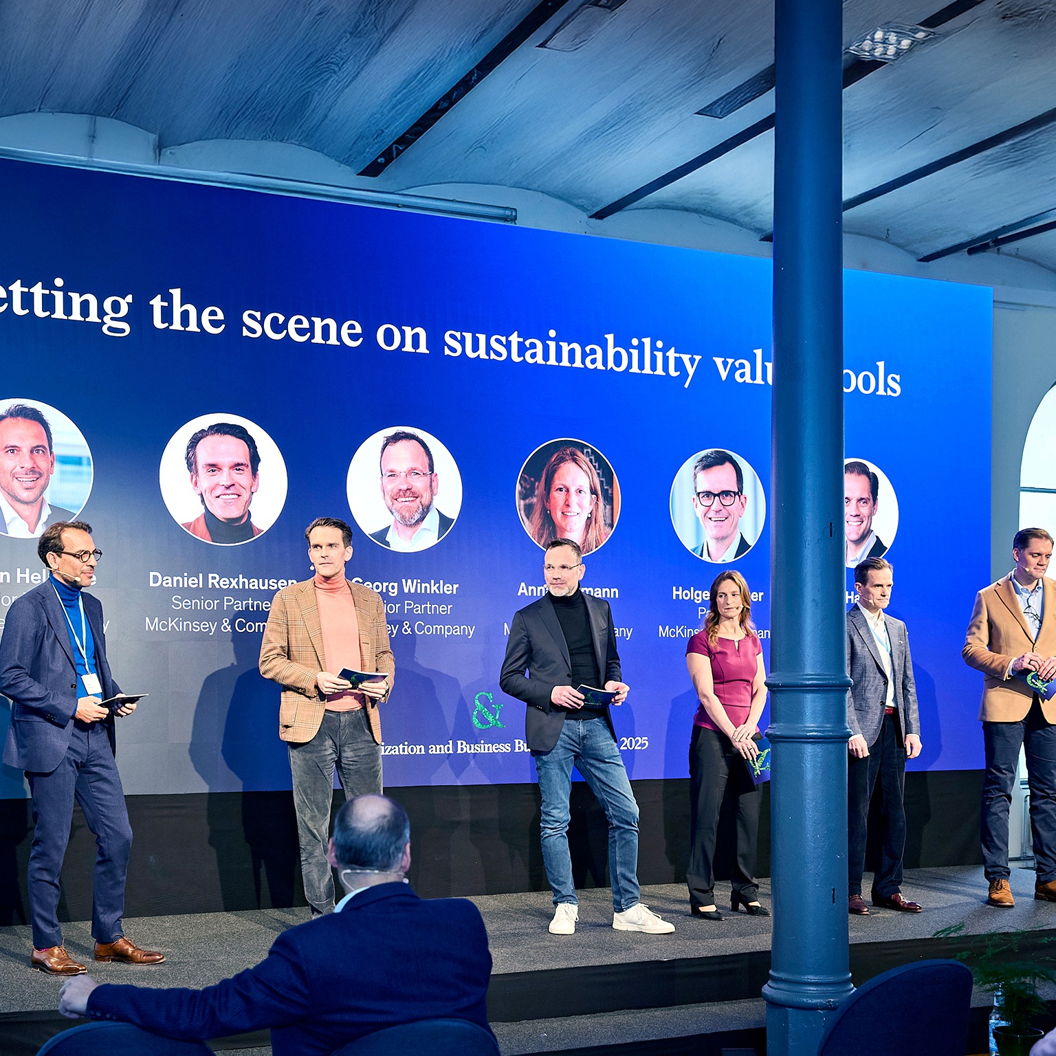 Speakers giving presentation on stage at Win Green & Grow: The McKinsey Business Building and Decarbonization Summit in Berlin.