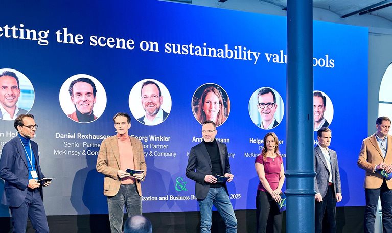 Speakers giving presentation on stage at Win Green & Grow: The McKinsey Business Building and Decarbonization Summit in Berlin.