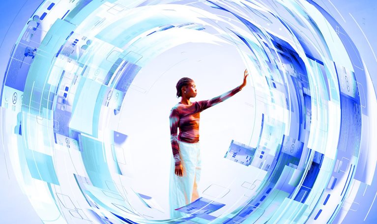 A woman stands at the center of a glowing, circular digital interface composed of layered blue and white translucent panels. She reaches out with her hand to touch the futuristic data displays that surround her in a dynamic, swirling formation.