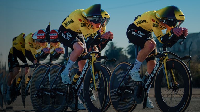 Team Visma | Lease a Bike riders in aerodynamic time-trial positions, racing at speed in a layered composition that emphasizes performance, precision, and momentum.
