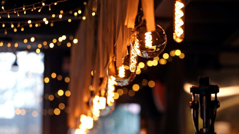 Small Local Business Concept. Low View For Cozy Bar Counter With Beer Tap Silhouette And Craft Electric Lamps And Garlands, Selective Focus, Copy Space