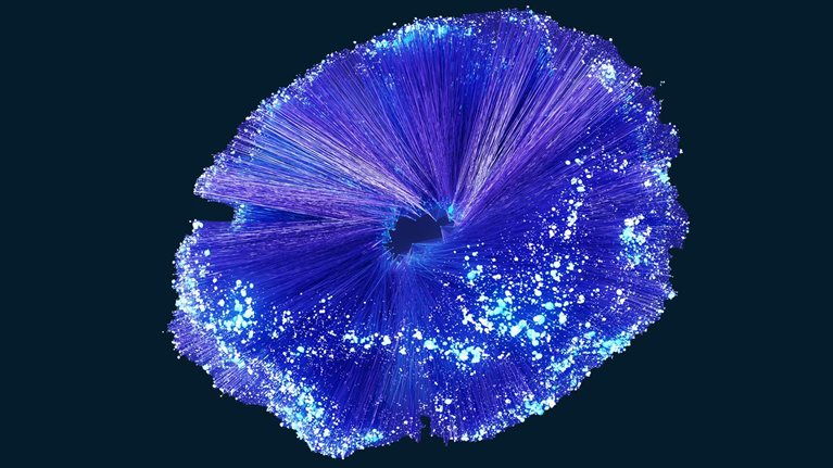 A vibrant, abstract burst of fine purple and blue lines radiating outward from a dark central opening, resembling an energetic digital explosion or data visualization.