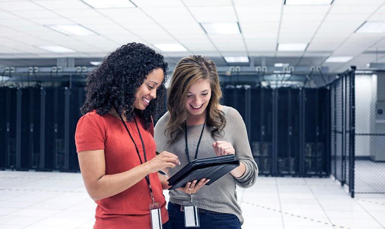 Businesswomen using tablet computer in server room