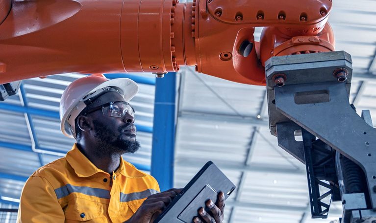 Engineer working with machinery at industrial manufacturing plant.