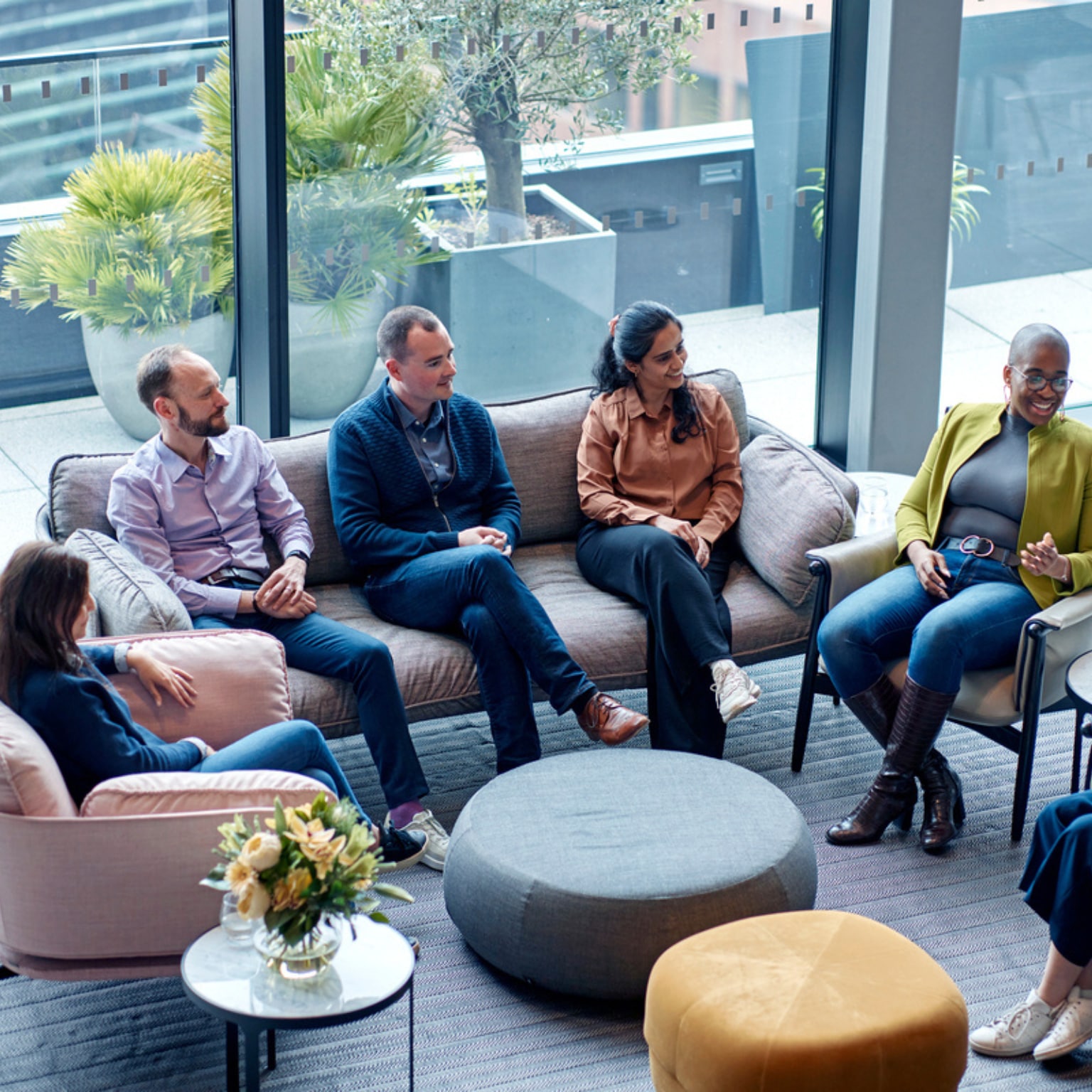 Five colleagues sitting in a group talking.