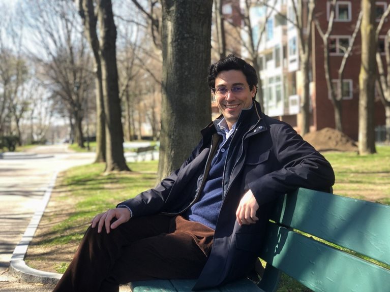Camil sitting on green bench in park