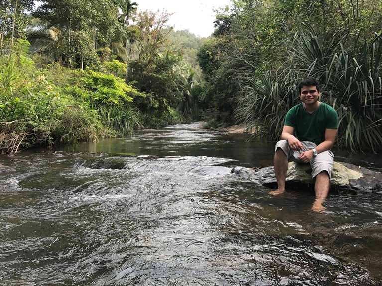 Imadh sitting on a river bank
