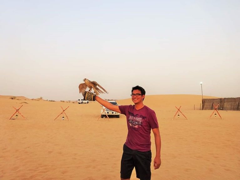 Andres holding a hawk in the desert