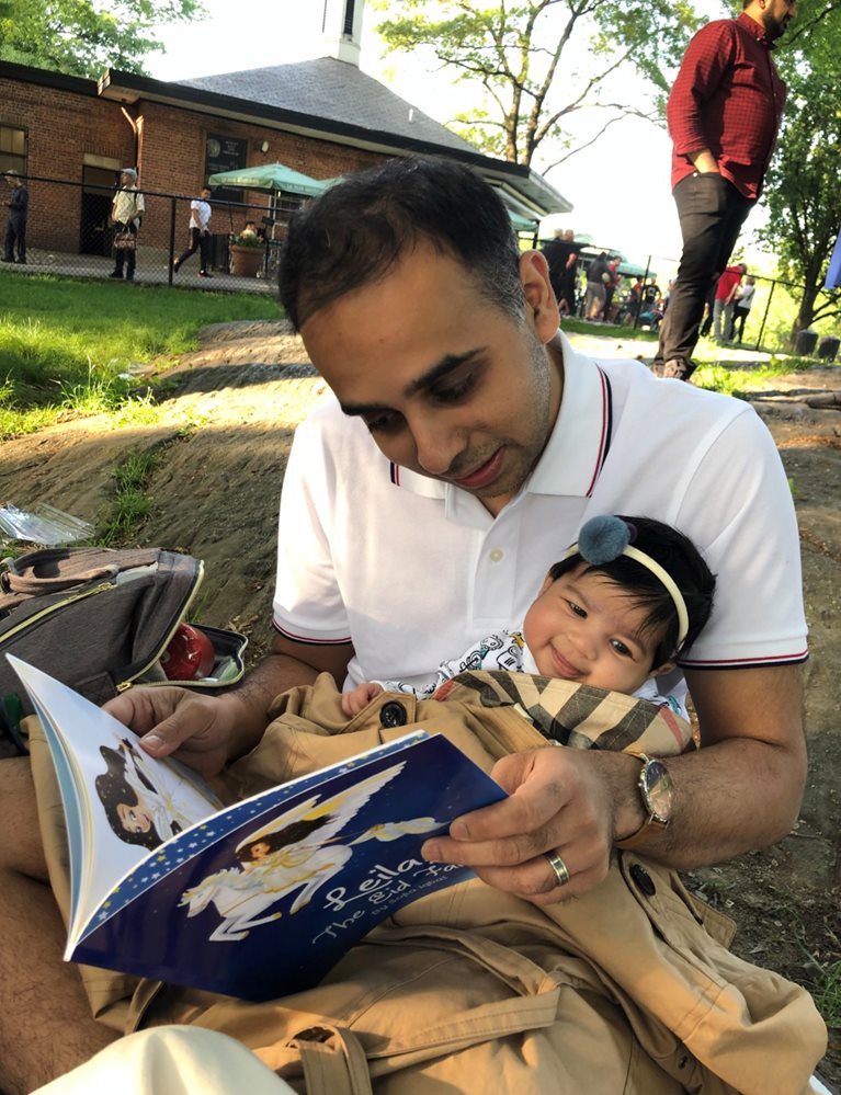 Wasim reading book to baby