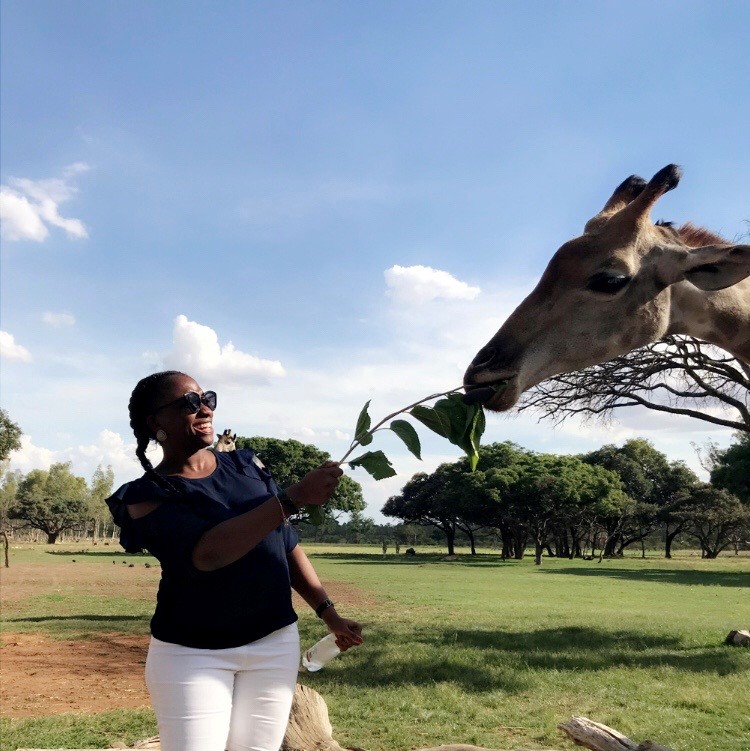 Tosin feeding a giraffe in Africa
