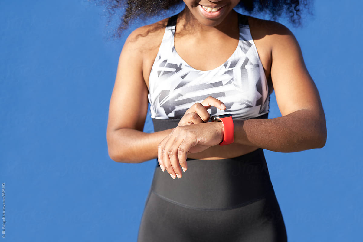 A photo of a person looking at their fitness monitor strapped to their wrist.