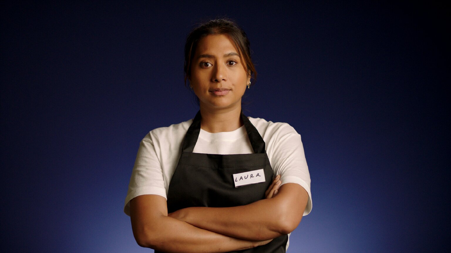 Frontline worker of color in an apron.