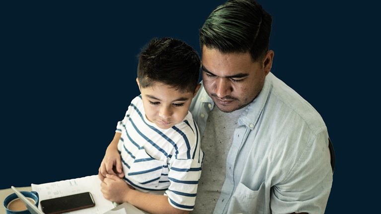 Father working with his son using laptop at home