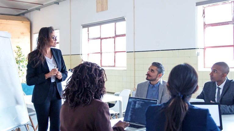Confident female business trainer working with employees