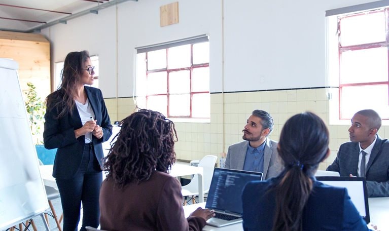 Confident female business trainer working with employees