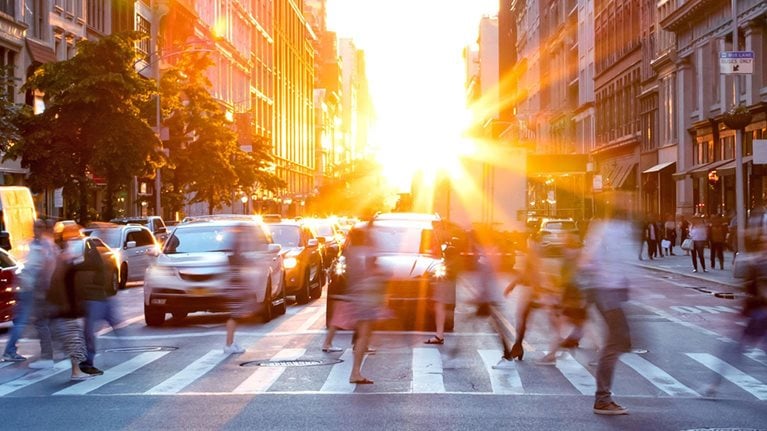 Sun setting between city buildings