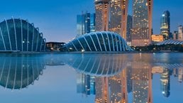 Gardens by the Bay and Singapore skyline reflection on blue water at blue hour in Singapore - stock photo 