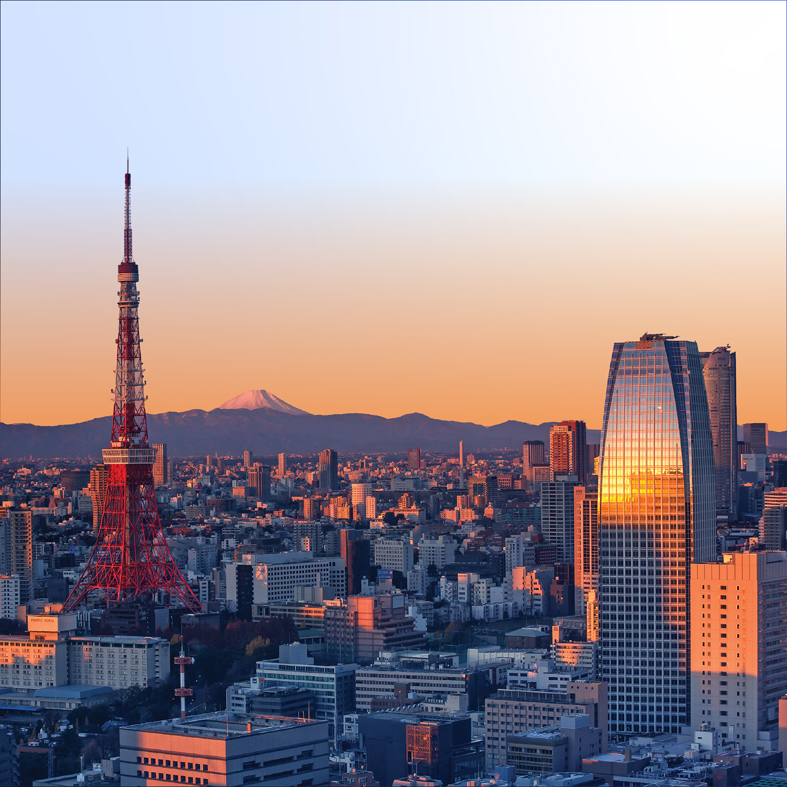 Tokyo Skyline at sunrise with Tokyo Tower and snowy Mount Fuji.