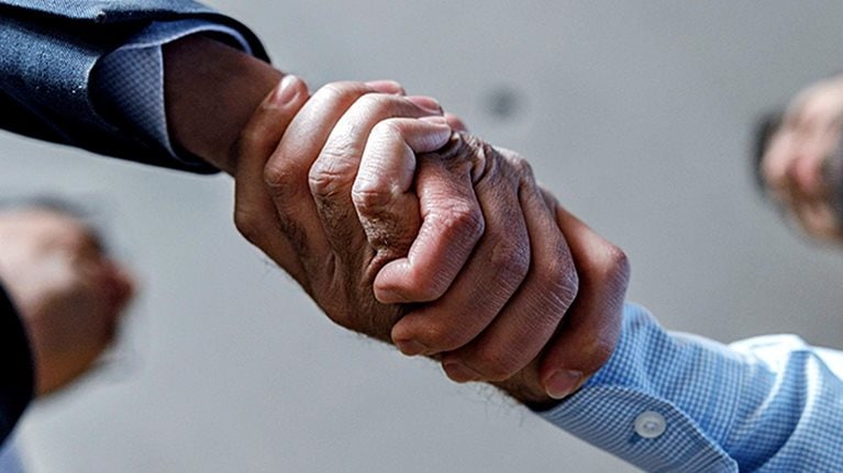 Close up of two businessmen shaking hands.