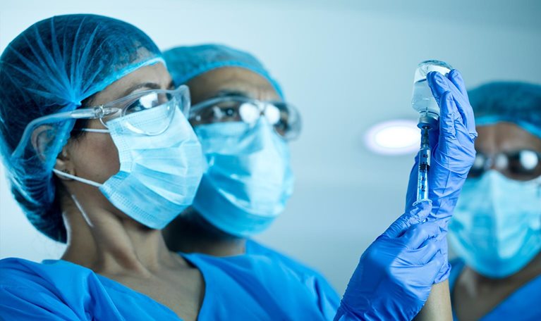 Doctors team preparing injection with COVID-19 vaccine - stock photo