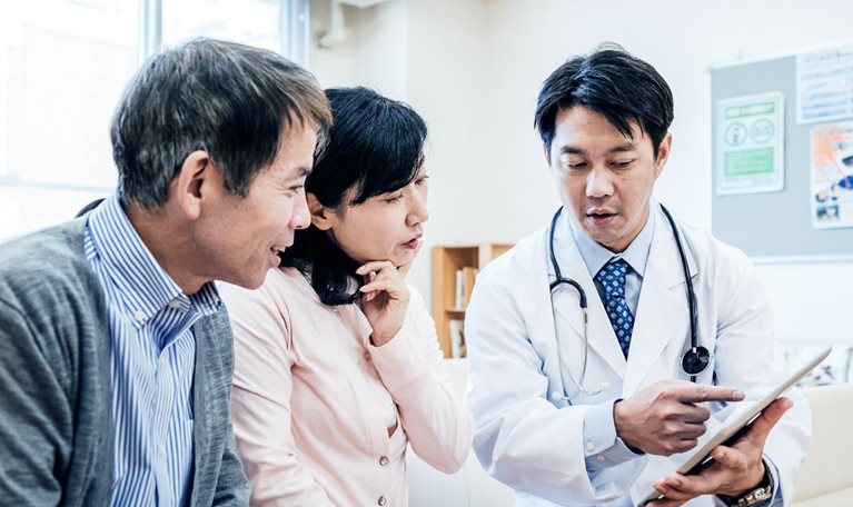 Two adults consulting a doctor