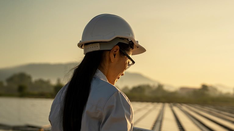 Female Asian engineer handle solar panel working on site of a floating solar farm.