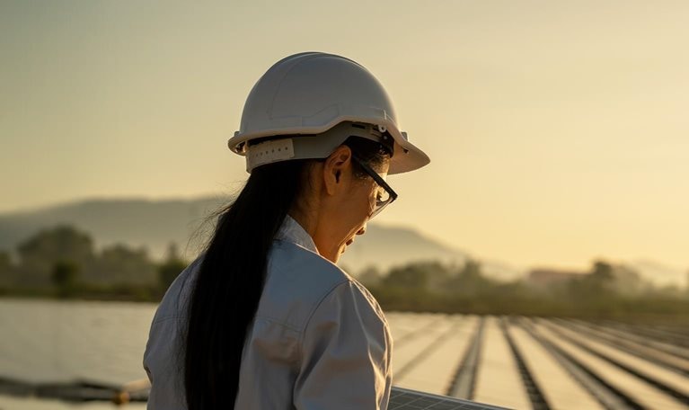 Female Asian engineer handle solar panel working on site of a floating solar farm.