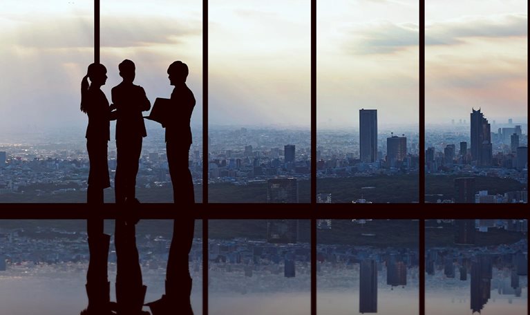 Businesspeople in front of urban cityscape. - stock photo