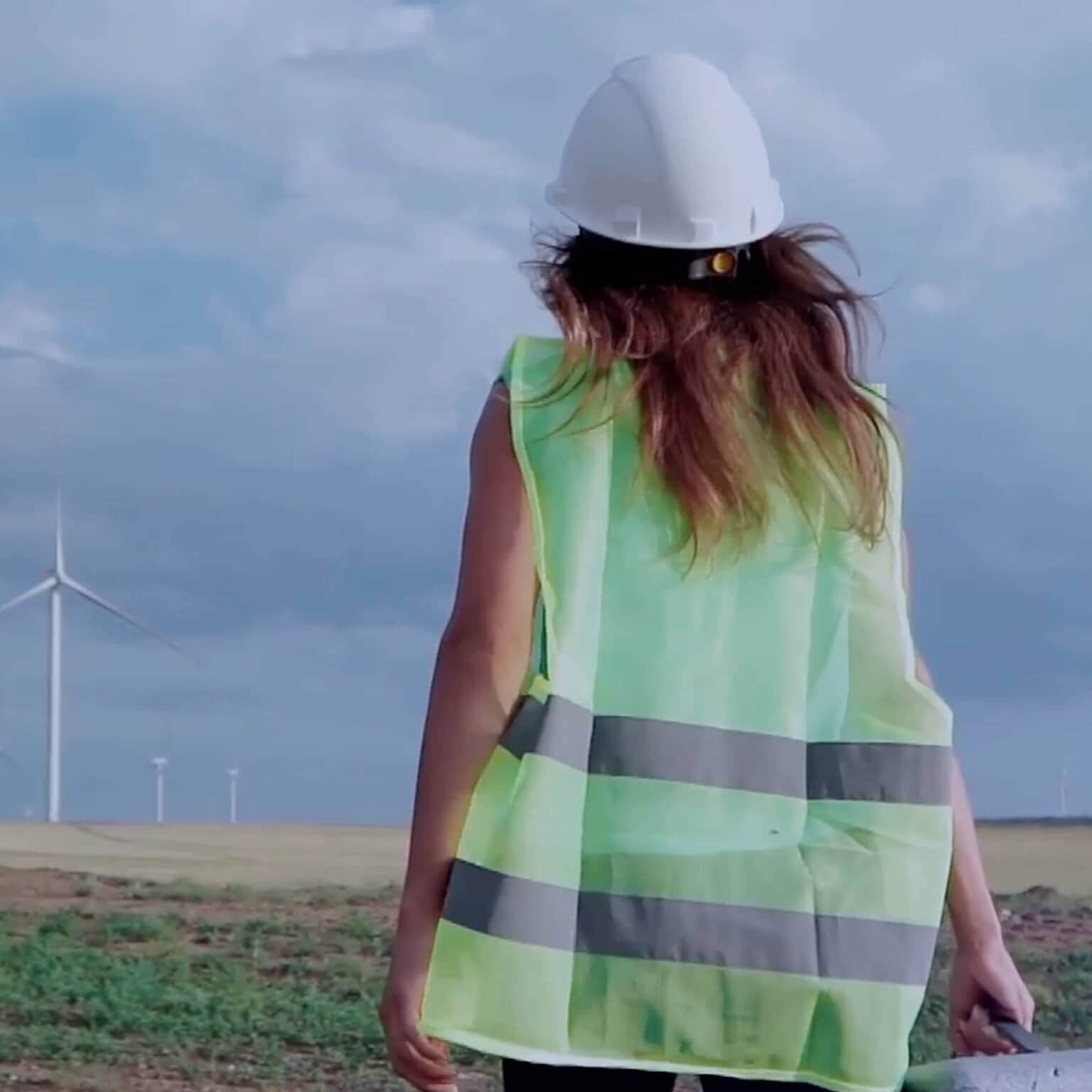 photo woman construction worker standing in front of wind turbines