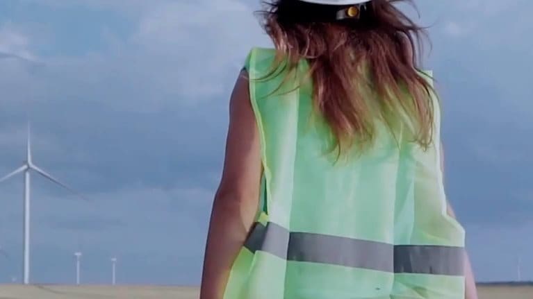 photo woman construction worker standing in front of wind turbines