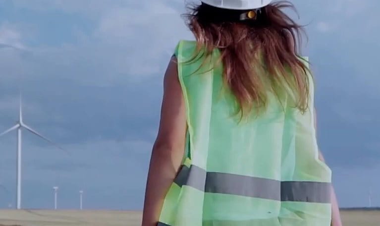 photo woman construction worker standing in front of wind turbines