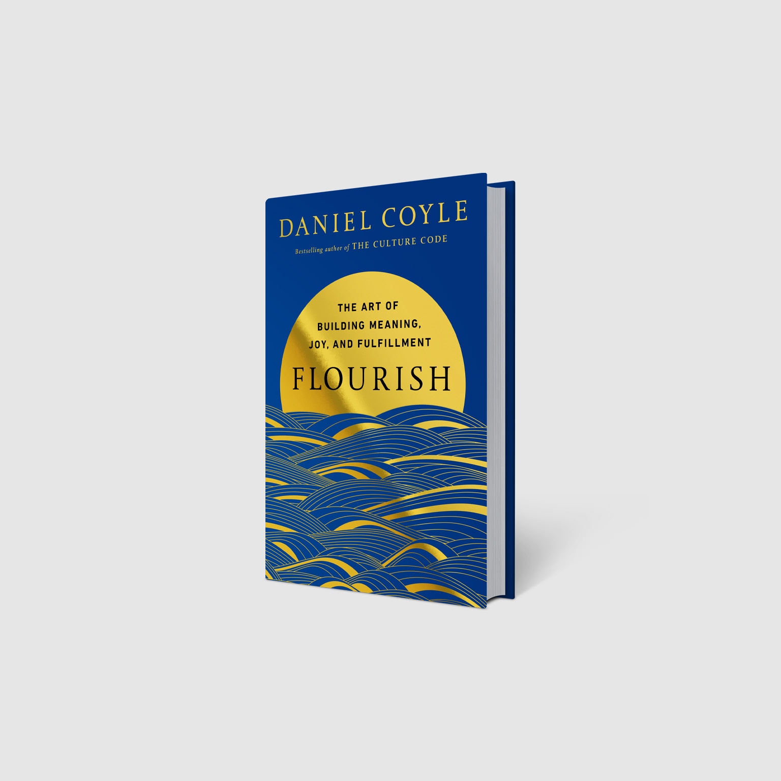 A 3D rendering of a book titled Flourish by Daniel Coyle, featuring a bold blue cover with gold typography and design elements. A large golden sun rises above stylized blue and gold waves, with the subtitle “The Art of Building Meaning, Joy, and Fulfillment” displayed prominently on the front.