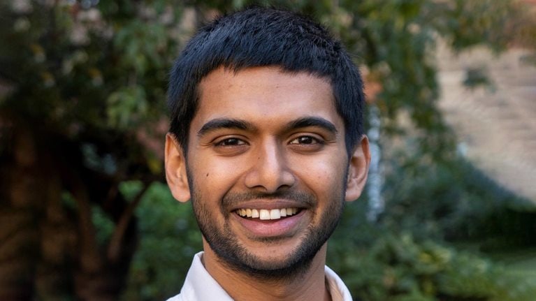 Portrait of a smiling Siddarth Shrikanth against natural greenery