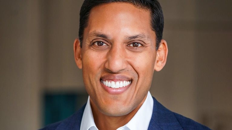 Portrait of a smiling Rajiv Shah in a blue suit jacket.