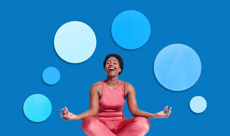 A joyful woman sitting cross-legged in a yoga pose, wearing a bright coral outfit and laughing with her eyes closed. The background is a solid blue with several floating circular shapes in different shades of blue, creating a calm and balanced visual effect.